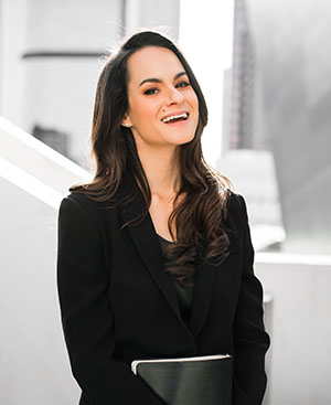 Ashley Stahl in a black top against light grey architectural background